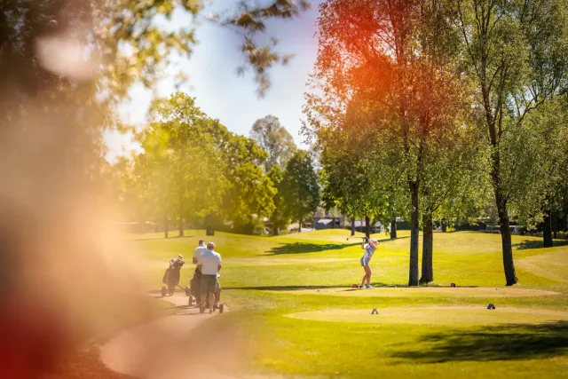 Golfers op de baan met publiek langs de fairway